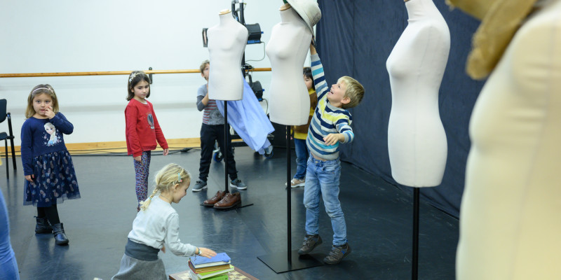 Taller de vestuari teatral amb peces de roba per a primària
